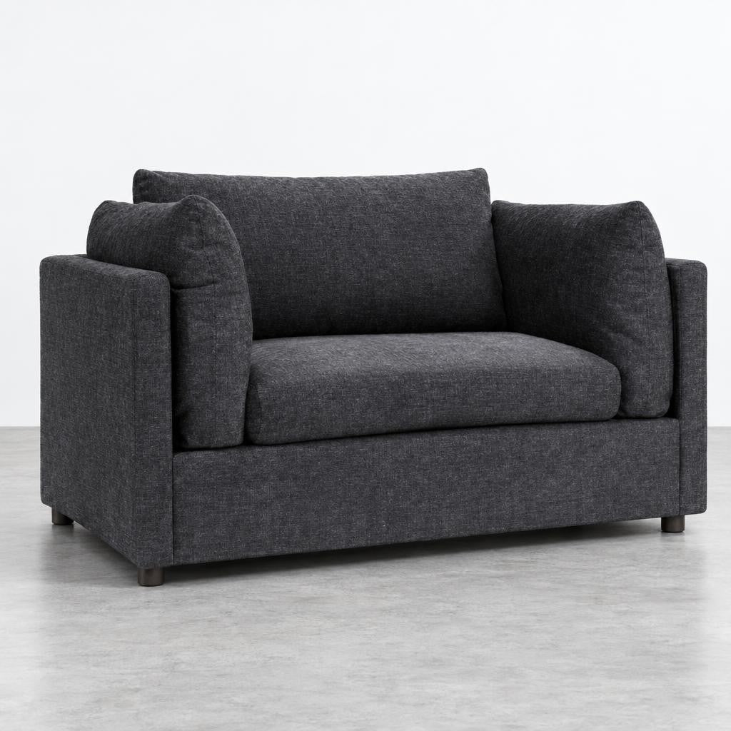 Dark gray modern loveseat with plush cushions on a light floor.