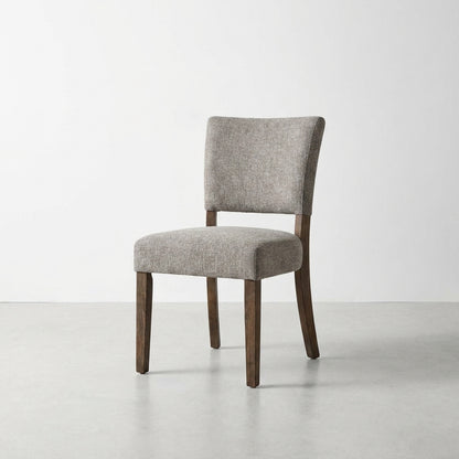 Gray upholstered chair with wooden legs on a white background.
