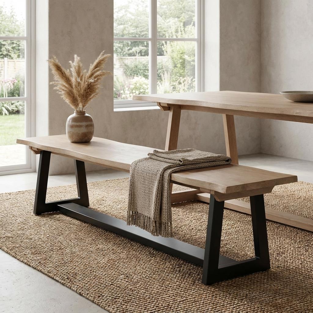 Minimalist dining area with wooden bench, vase, and throw.