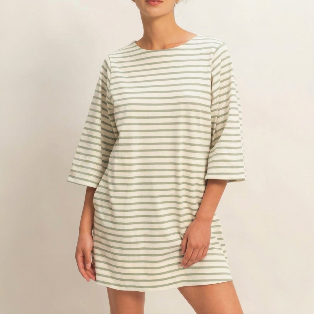 Person in a striped dress against a neutral background.