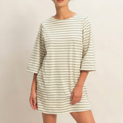 Person in a striped dress against a neutral background.