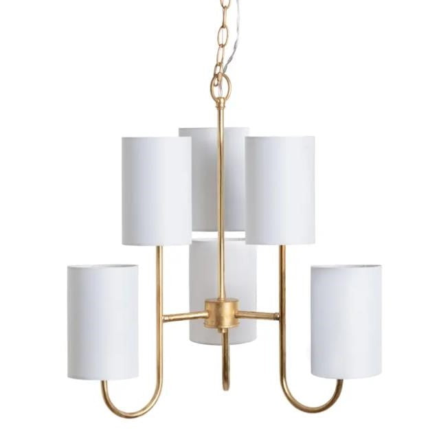 Gold chandelier with five white cylindrical shades.