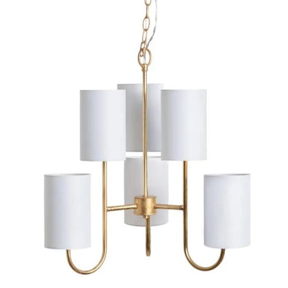 Gold chandelier with five white cylindrical shades.