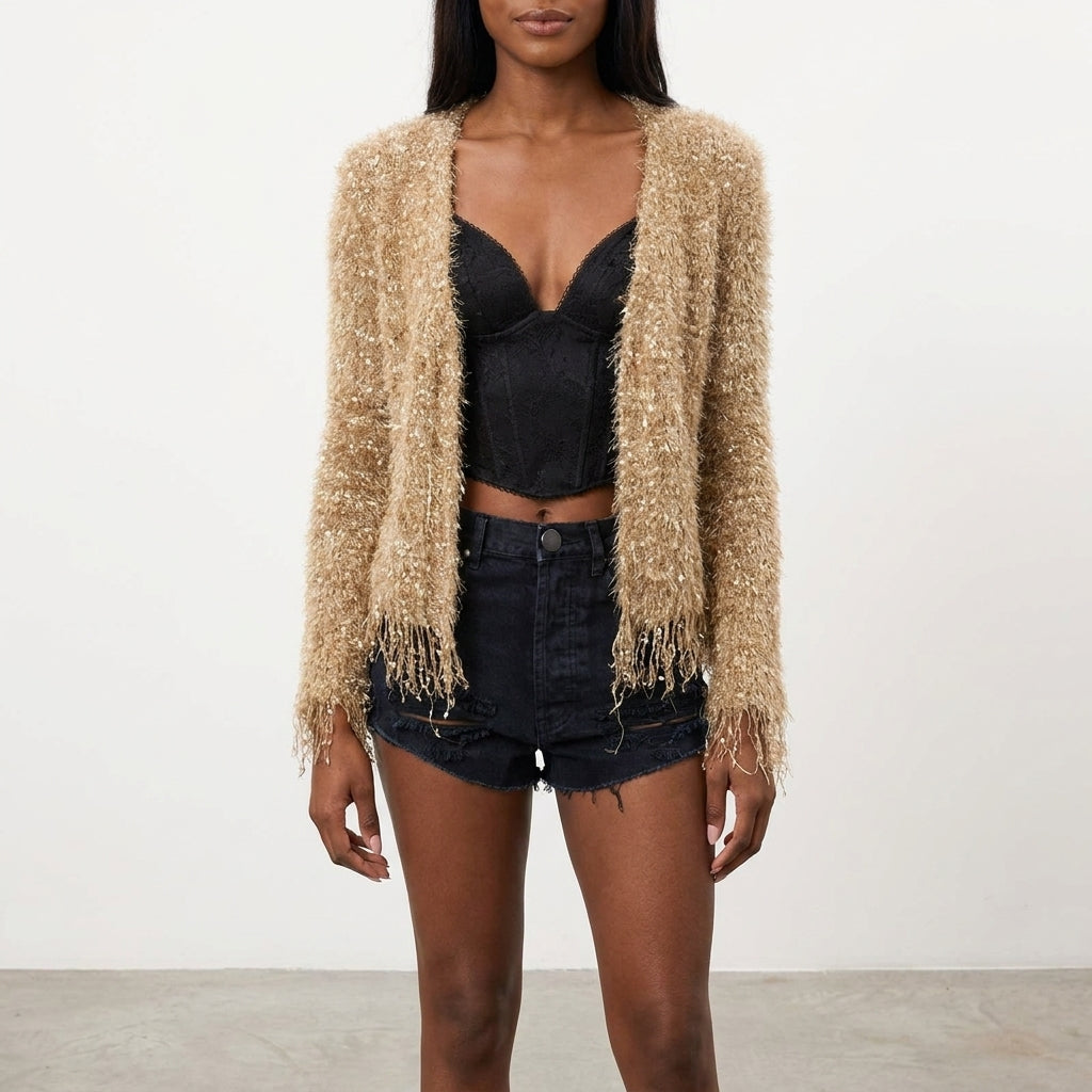 Woman in a fuzzy cardigan, black top, and denim shorts.
