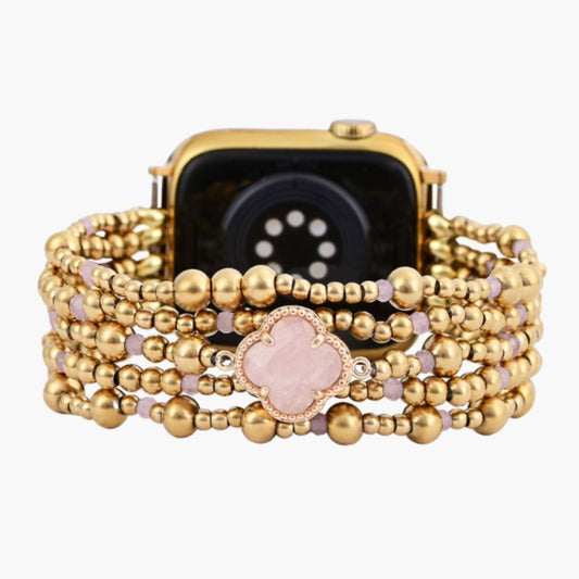 Gold beaded watch band with pink accents and flower detail.