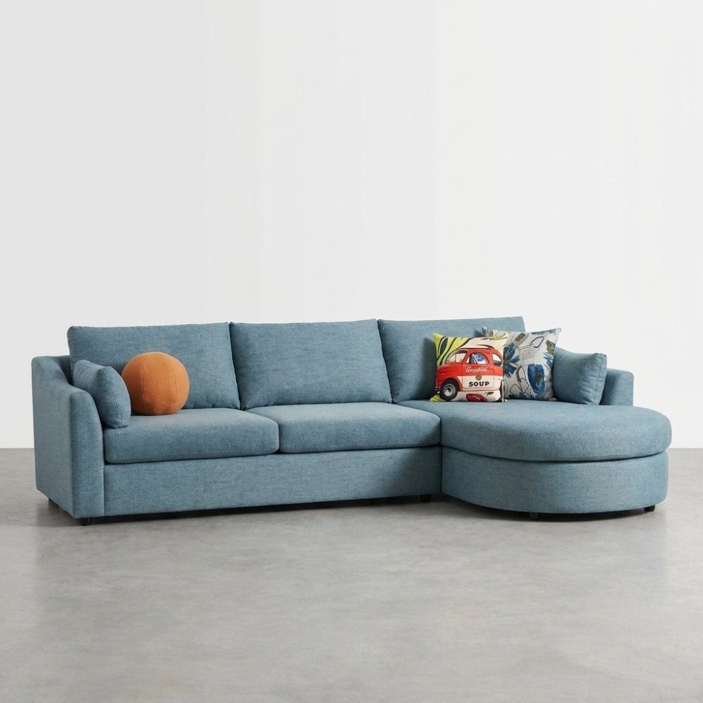 Blue sectional sofa with colorful cushions on a gray floor.