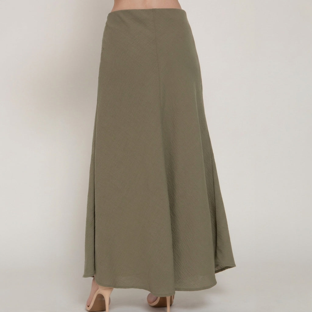 Long olive skirt with nude heels, back view.