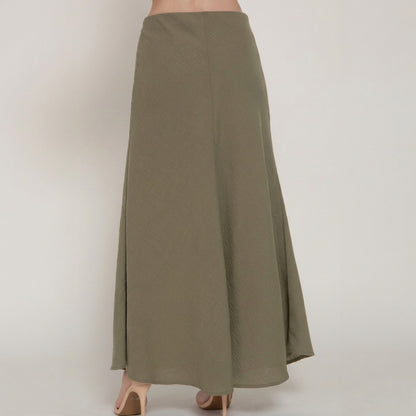 Long olive skirt with nude heels, back view.