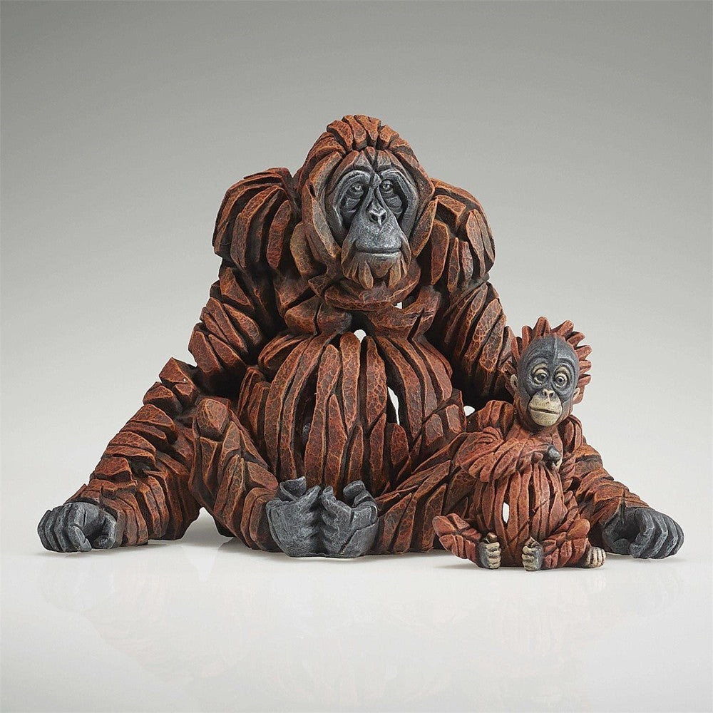 Carved orangutan sculptures of an adult and baby with textured, layered design.