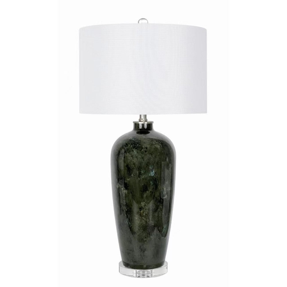 Dark vase lamp with white shade on clear base.