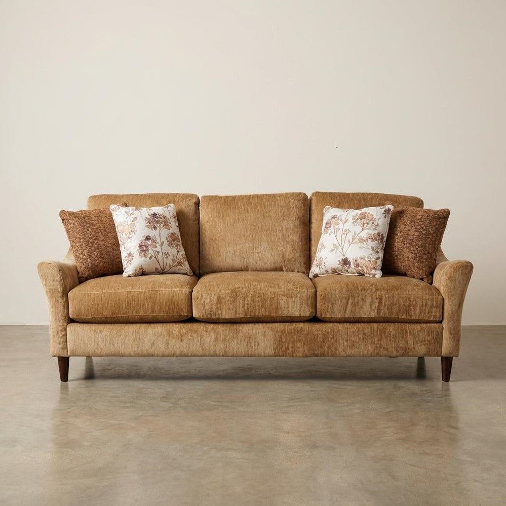Brown sofa with patterned pillows on a plain background.