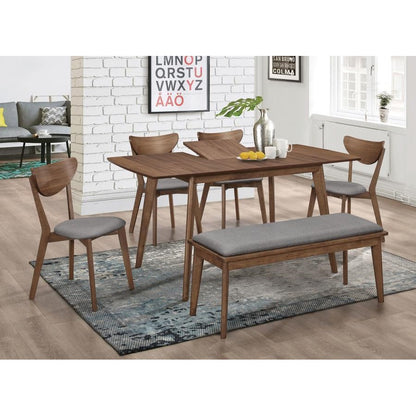 Dining set with wooden table, chairs, bench, and wall art in a bright room.