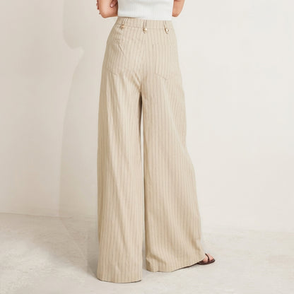 Beige wide-legged, high-waisted pants with a white ribbed top and sandals.