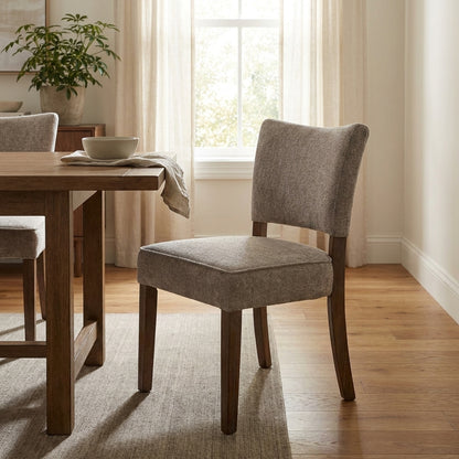 Cozy dining area with wooden table, gray chairs, and natural light.