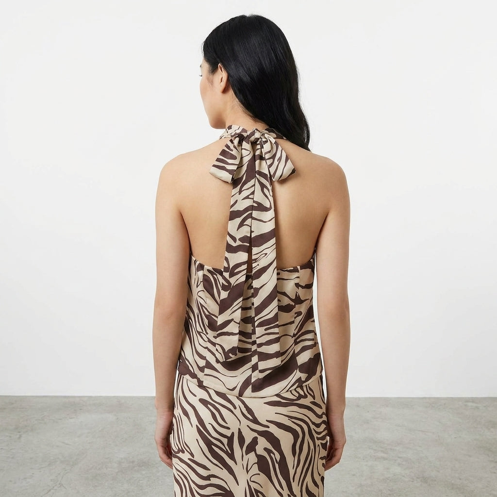 Woman in zebra print dress with tied back, facing away.