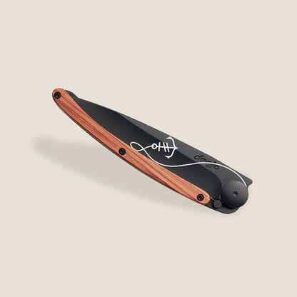Folding knife with engraved wooden handle and sleek black blade design.