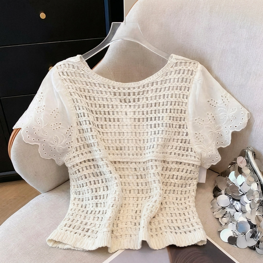 White crochet top with embroidered sleeves on chair.