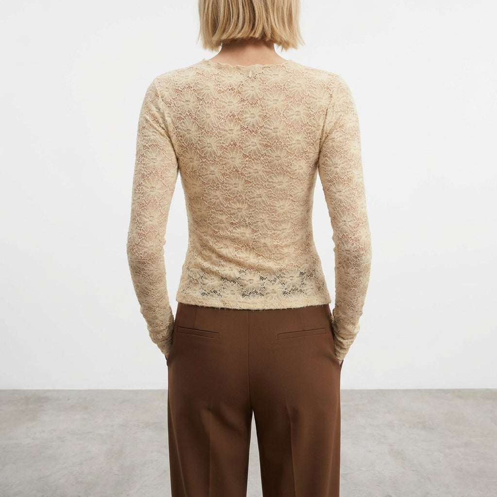 Person in lace top and brown pants, facing away.