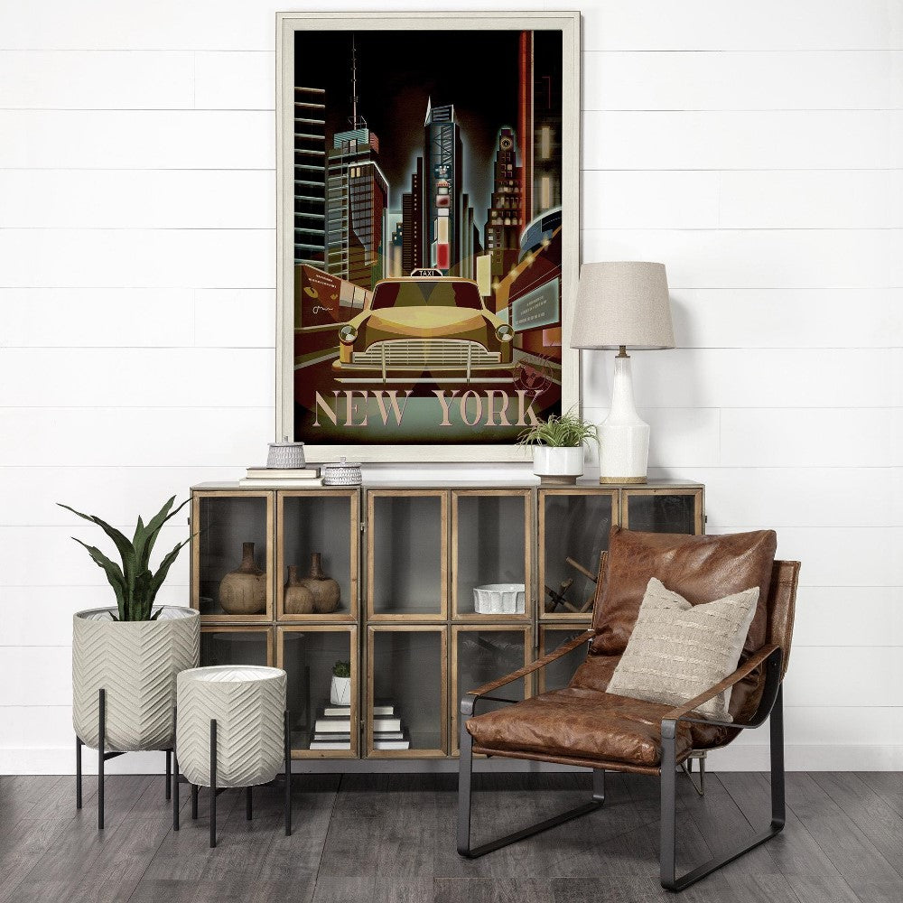 Modern room with a New York cityscape poster, leather chair, and plants.