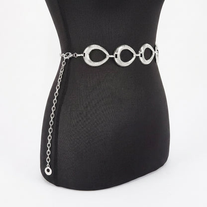 Silver circular belt on a black mannequin torso.