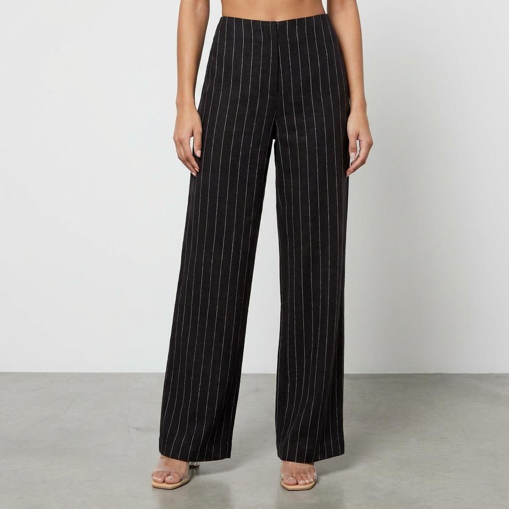 Woman wearing black pinstripe wide-leg pants and heels.