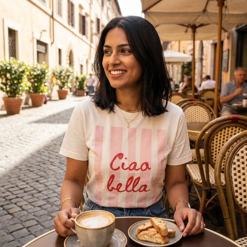 Woman enjoys coffee at a cafe, smiling outdoors.