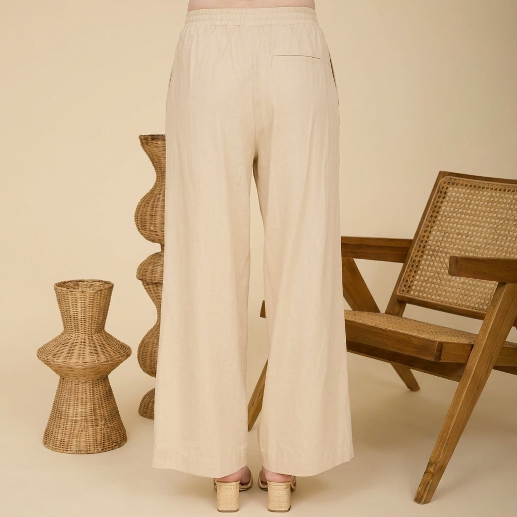 Beige pants styled with wicker decor and chair backdrop.