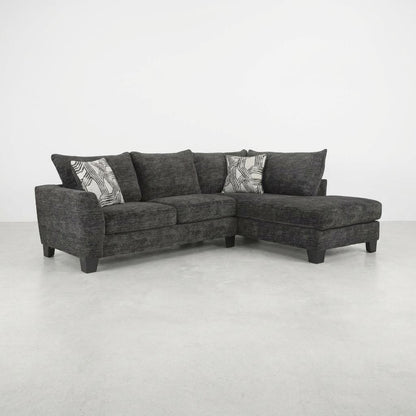 Dark gray sectional sofa with patterned pillows.
