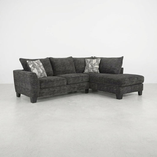 Dark gray sectional sofa with patterned pillows.