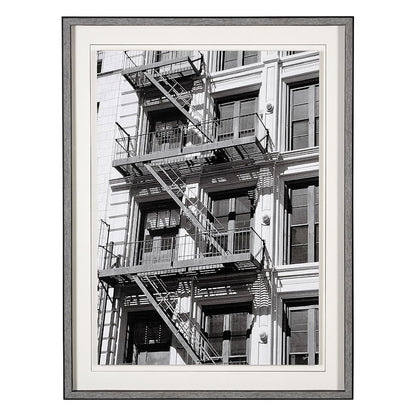 Black and white photo of a building with fire escapes.