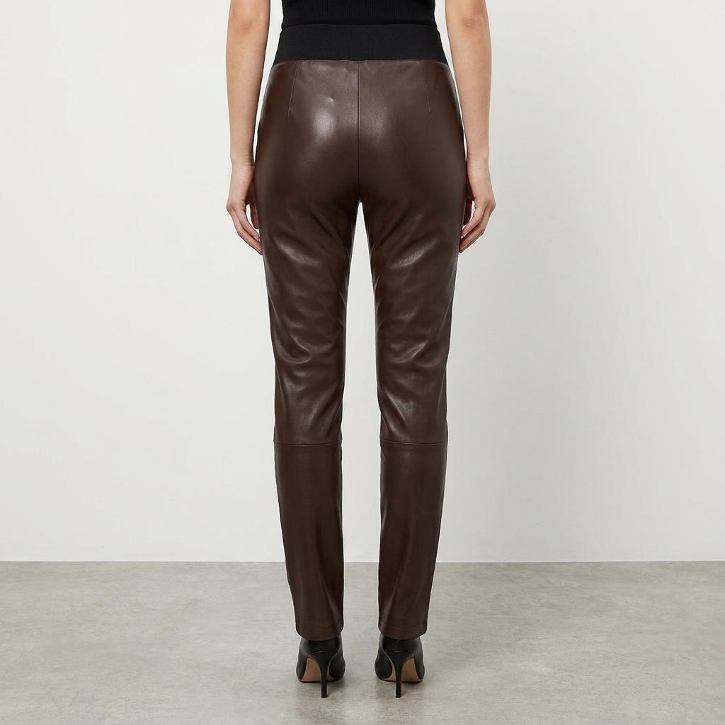 Rear view of brown leather pants worn with black heels.