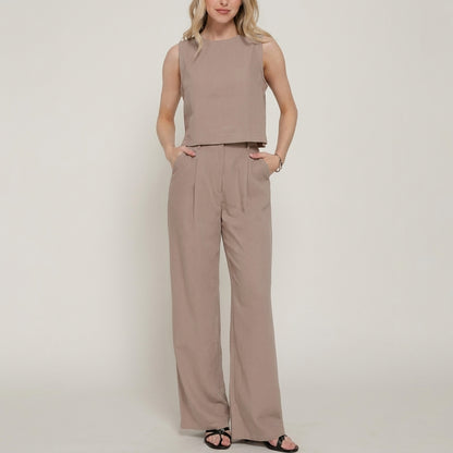 Woman in matching beige crop top and wide-leg pants.