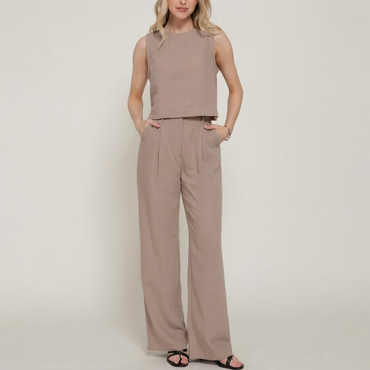 Woman in matching beige crop top and wide-leg pants.