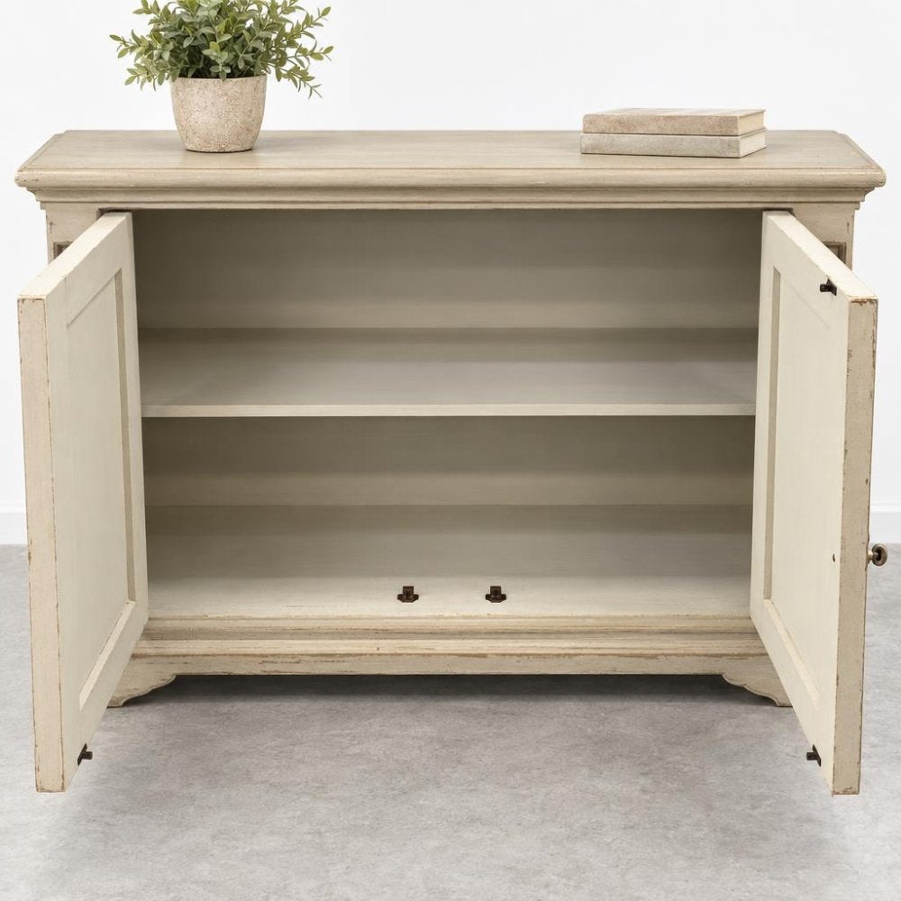 Open beige cabinet with a plant and books on top.