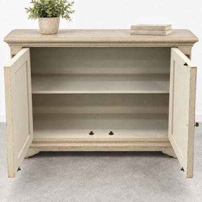 Open beige cabinet with a plant and books on top.