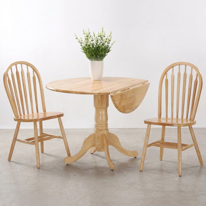 Wooden dining set with vase of flowers on round table, two chairs beside it.