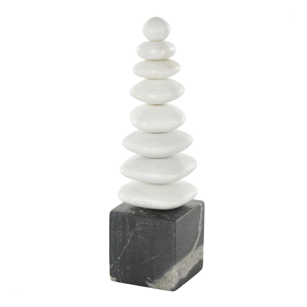 Stones stacked on a dark cube base, forming a pyramid shape.