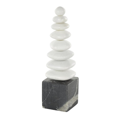 Stones stacked on a dark cube base, forming a pyramid shape.