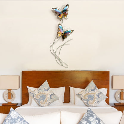 Bedroom with butterfly wall art above a bed and decorative pillows.