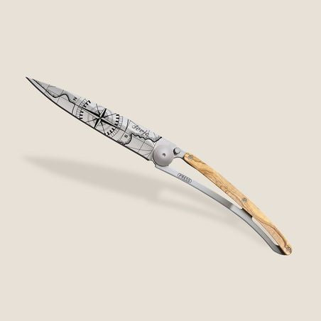 Intricately designed folding knife with wooden handle and engraved blade.