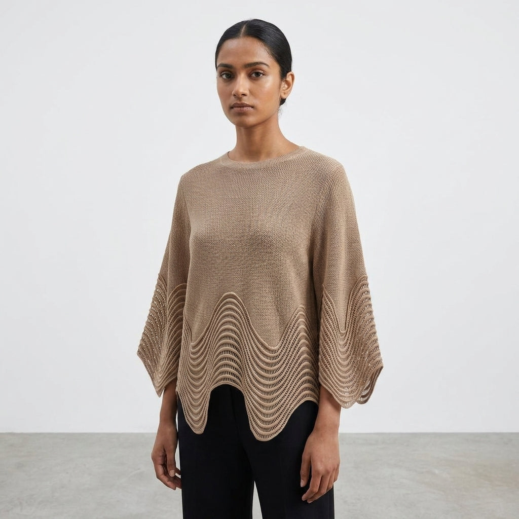 Person in a brown sweater with textured hem, standing against a plain background.