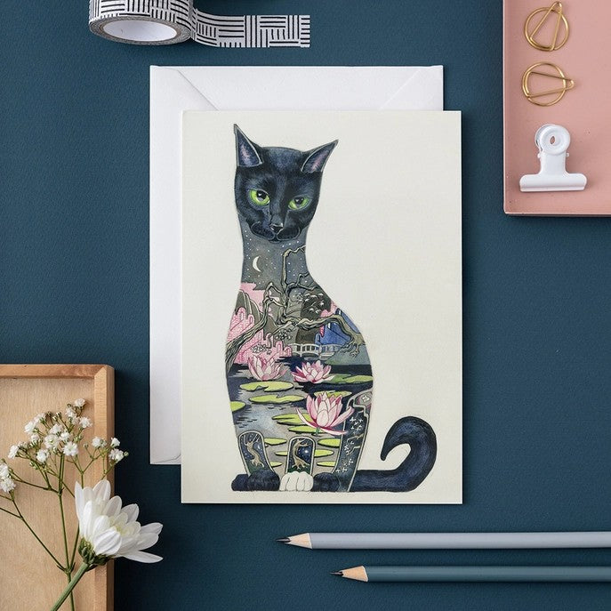 Artistic cat illustration on a card with lilies and a night scene.