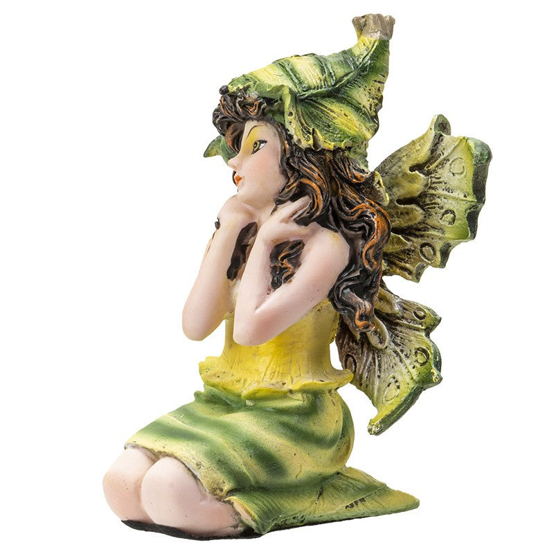 A fairy figurine in a green leaf dress and hat, sitting with wings outspread.