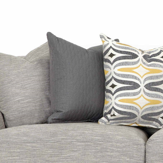 Three decorative pillows on a gray sofa.