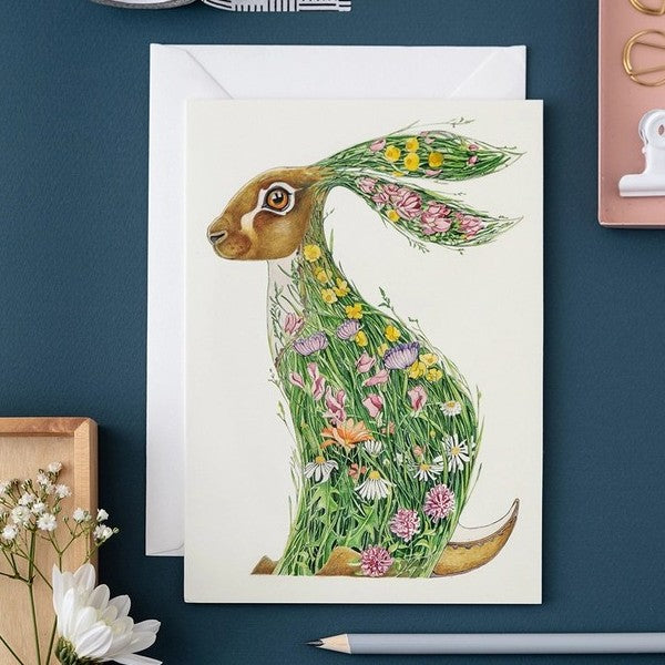 Artistic rabbit card with floral design on a desk.