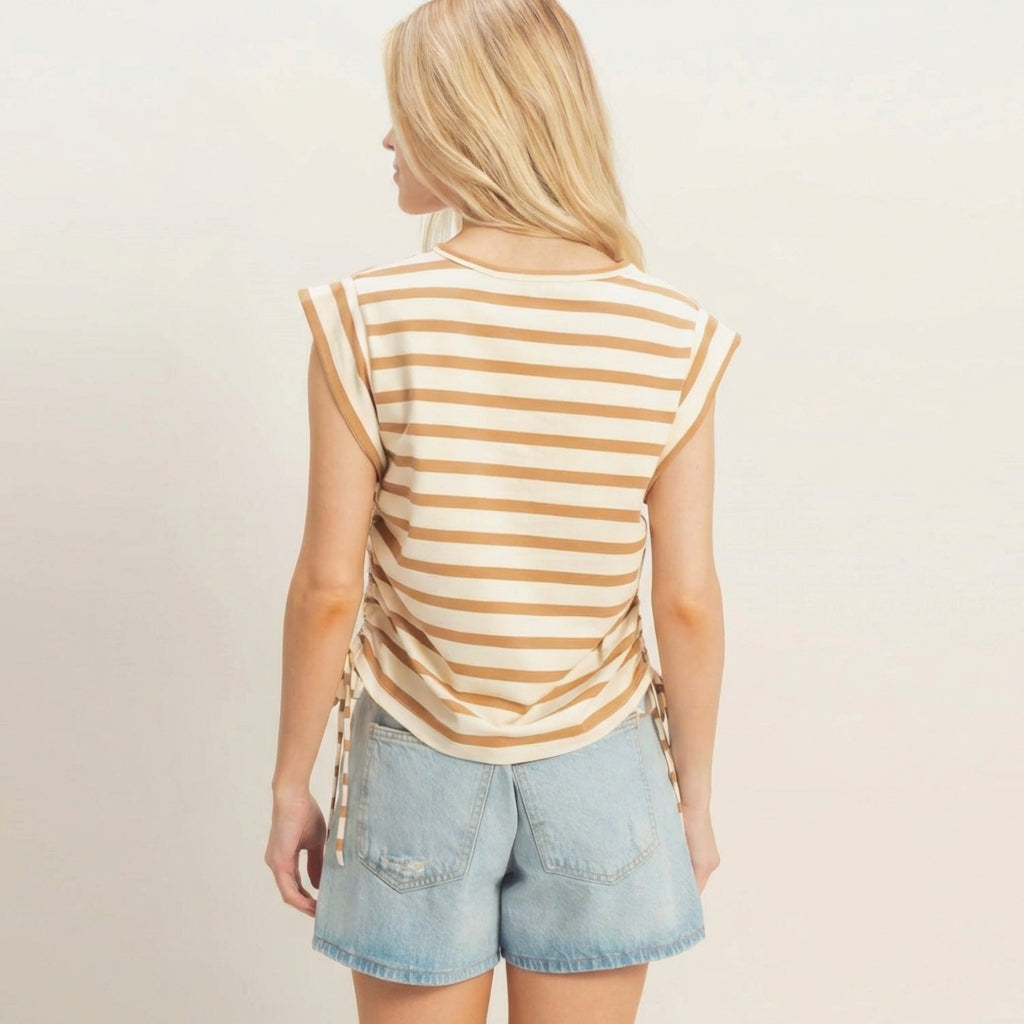 Person in striped top and denim shorts, facing away.