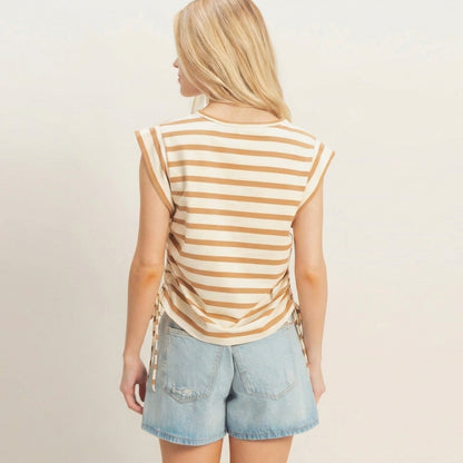 Person in striped top and denim shorts, facing away.