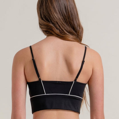 Person with long hair in black strappy top, back view.