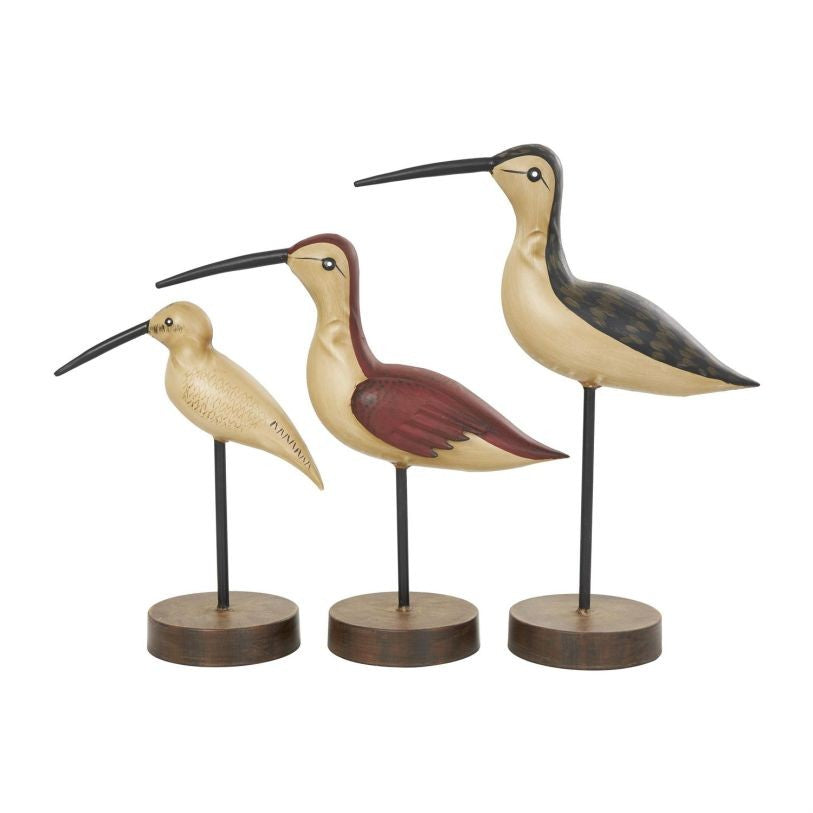 Three stylized bird sculptures on wooden stands.