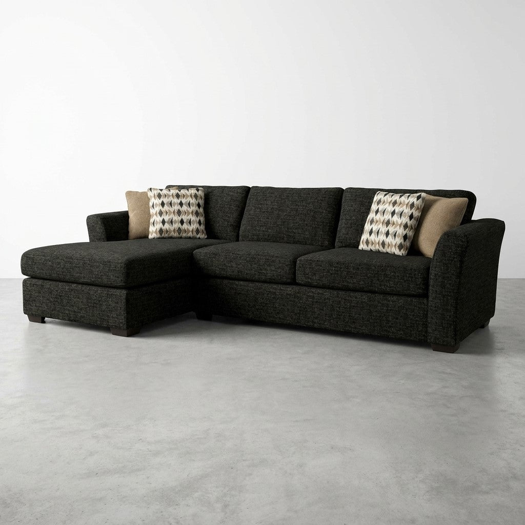 Dark L-shaped sofa with patterned pillows on a gray floor.